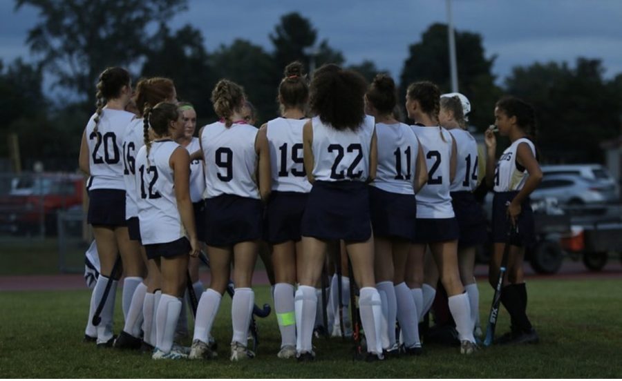 Girls+Varsity+Field+Hockey+talking+strategy+on+the+edge+of+the+field+for+their+game