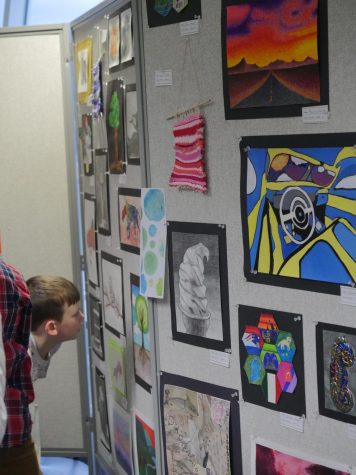 Student looks at art work at Fine Arts Night.
